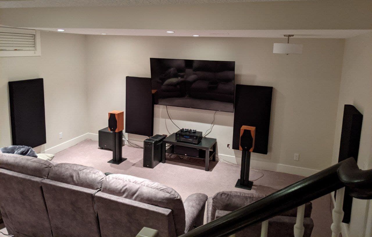 four black acoustic panels mounted on the walls in my home theatre